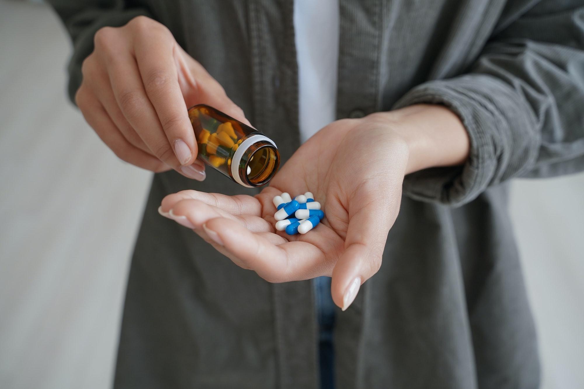 Young woman pouring pills into her hand, realizing she needs residential treatment at Saving My Tomorrow