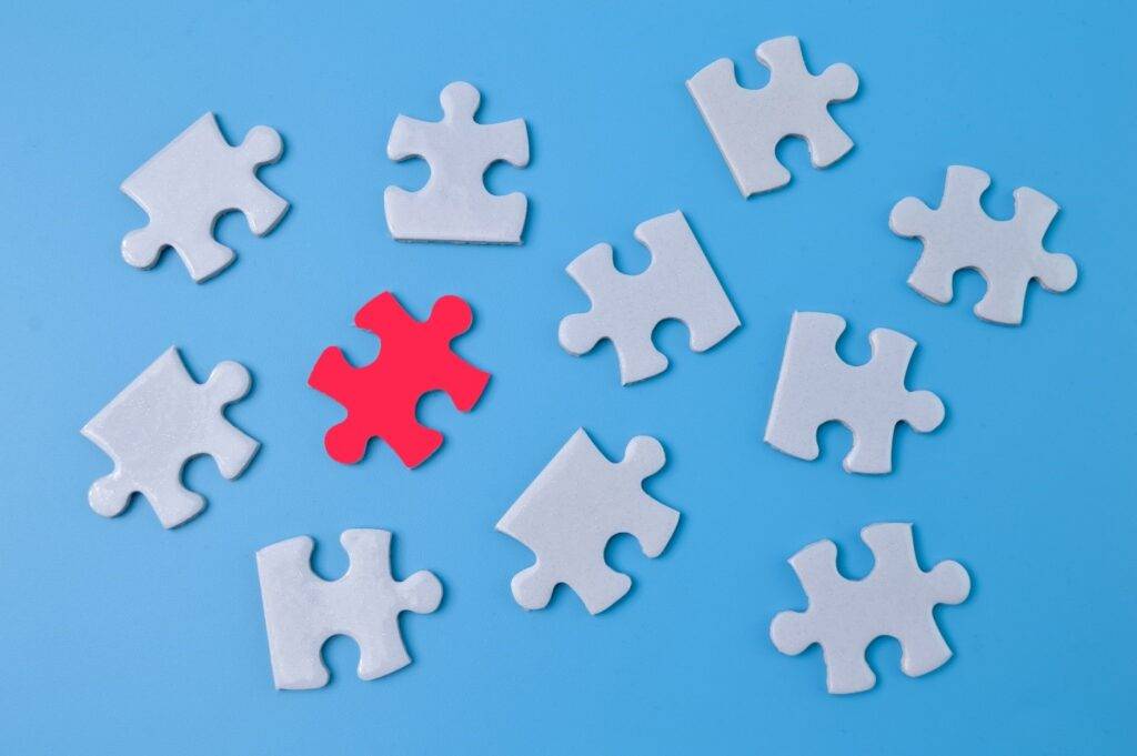 Puzzle pieces with one red piece, symbolizing the need for destigmatizing addiction