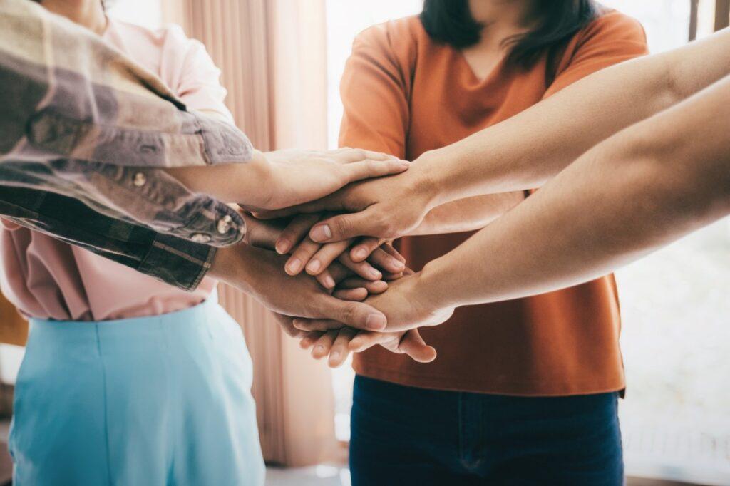 People with their hands in a circle, rejoicing continuation of care