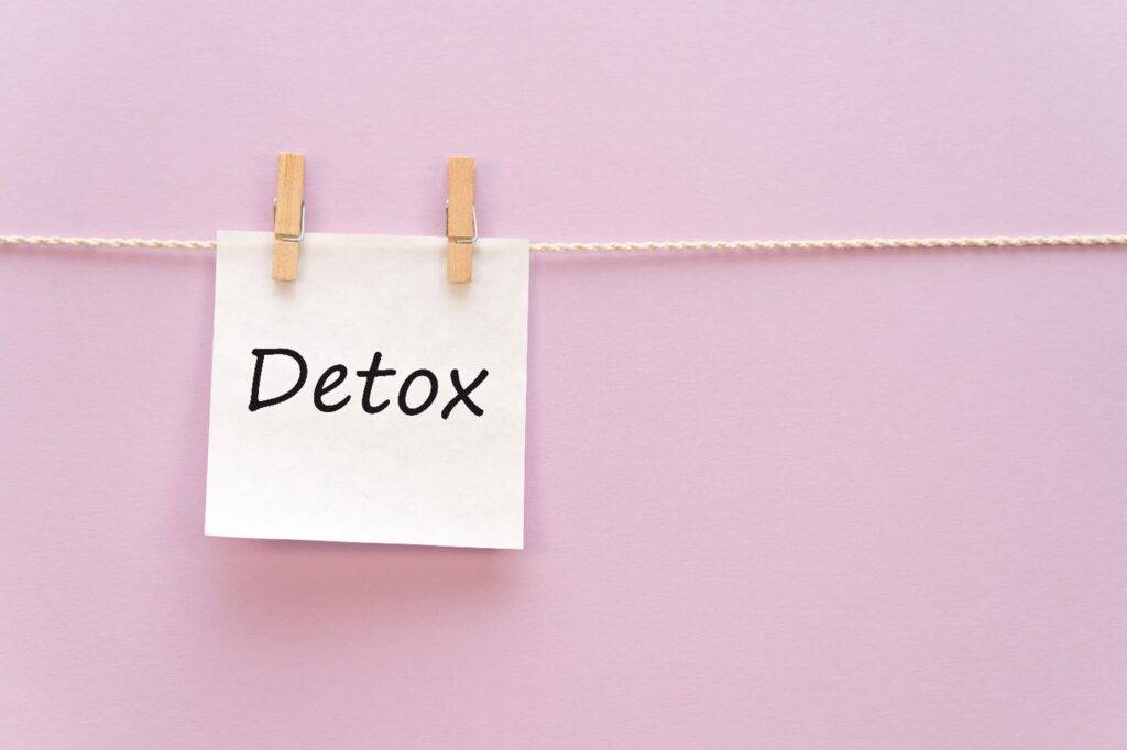 "detox" on a piece of paper hanging on a close line.