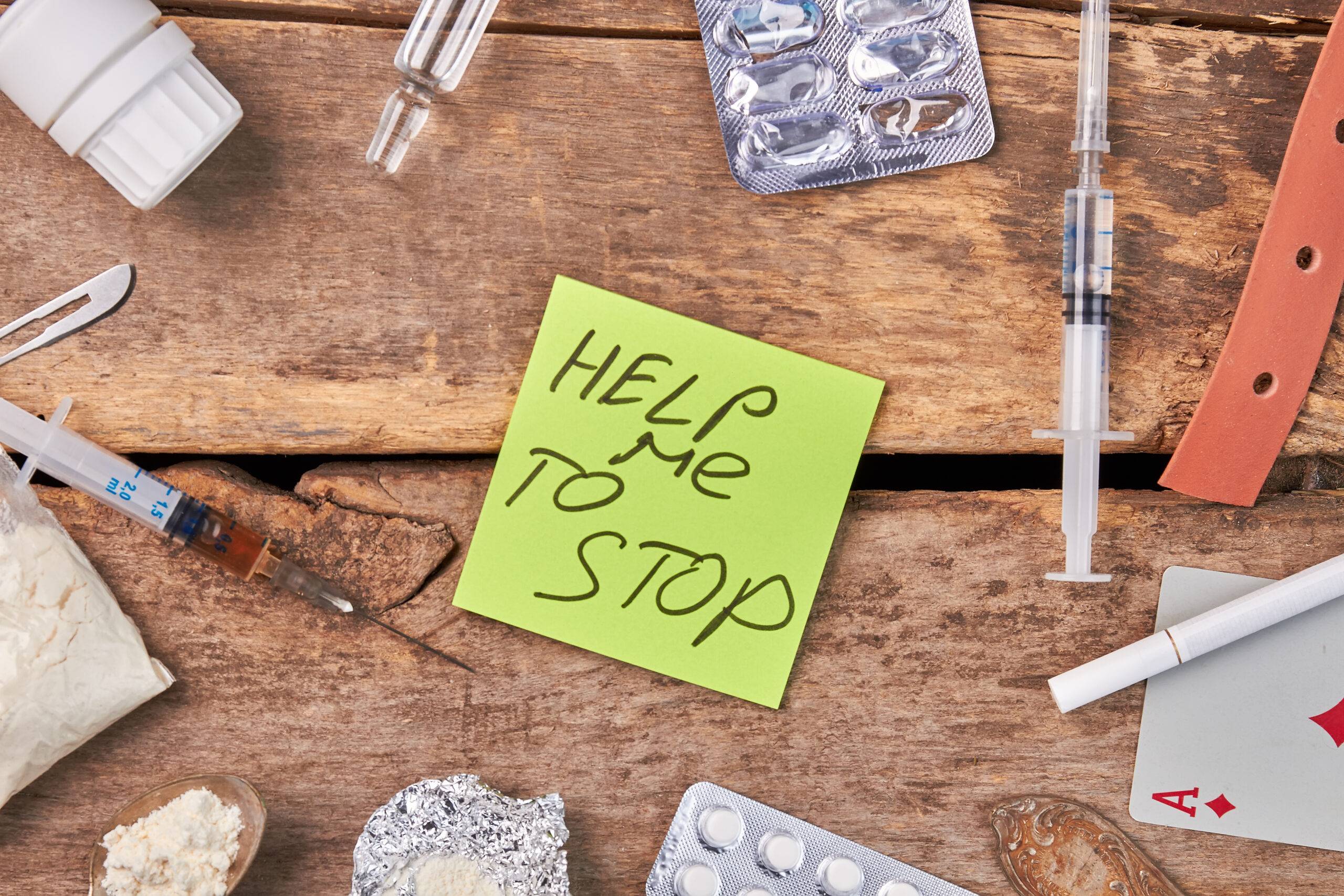 "Help me to stop" on sticky note alongside various substances, signifying the need to stop substance abuse